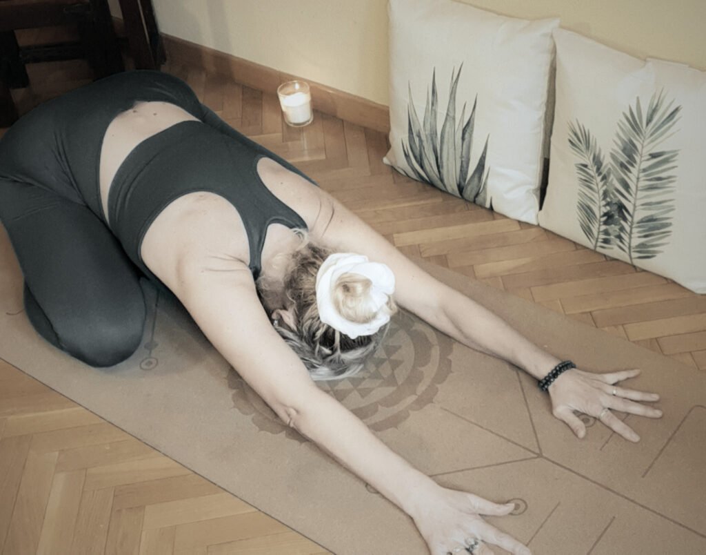 Marya Vázquez en la postura de balasana en Yin Yoga Althaia rodeada de velas