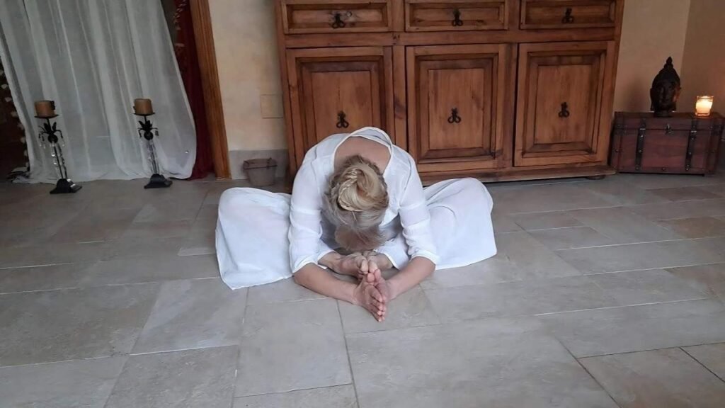 Marya Vázquez en la postura de la mariposa o badhakonasana, vestida de blanco en yin yoga althaia