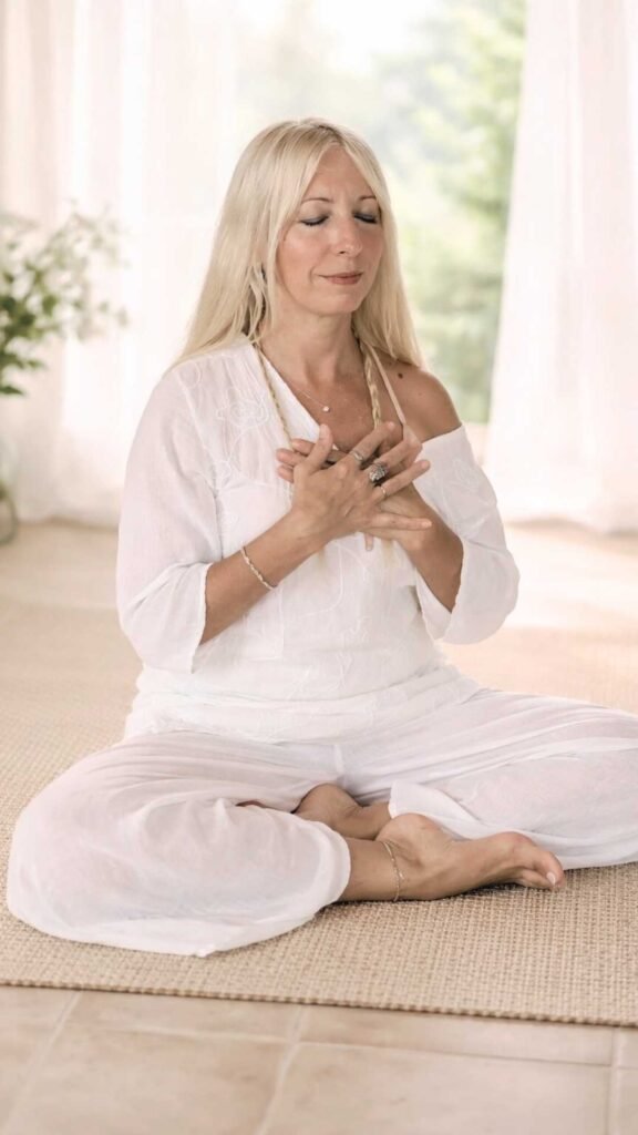 Marya Vázquez en Yin Yoga Althaia parcticando meditación somáticadel ritual althaia Marya Vázquez vestida de blanco en la clase de meditación somática en la postura de yoga sukhasana en Yin Yoga Althaia