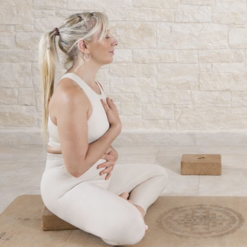 Marya vestida en tonos claros en meditación & yoga online